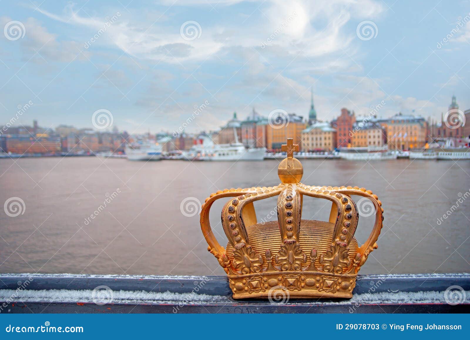 Swedish kingdom golden crown. Golden crown on Skeppsholmen bridge, symbol of the Kingdom of Sweden, with Stockholm Old Town in background