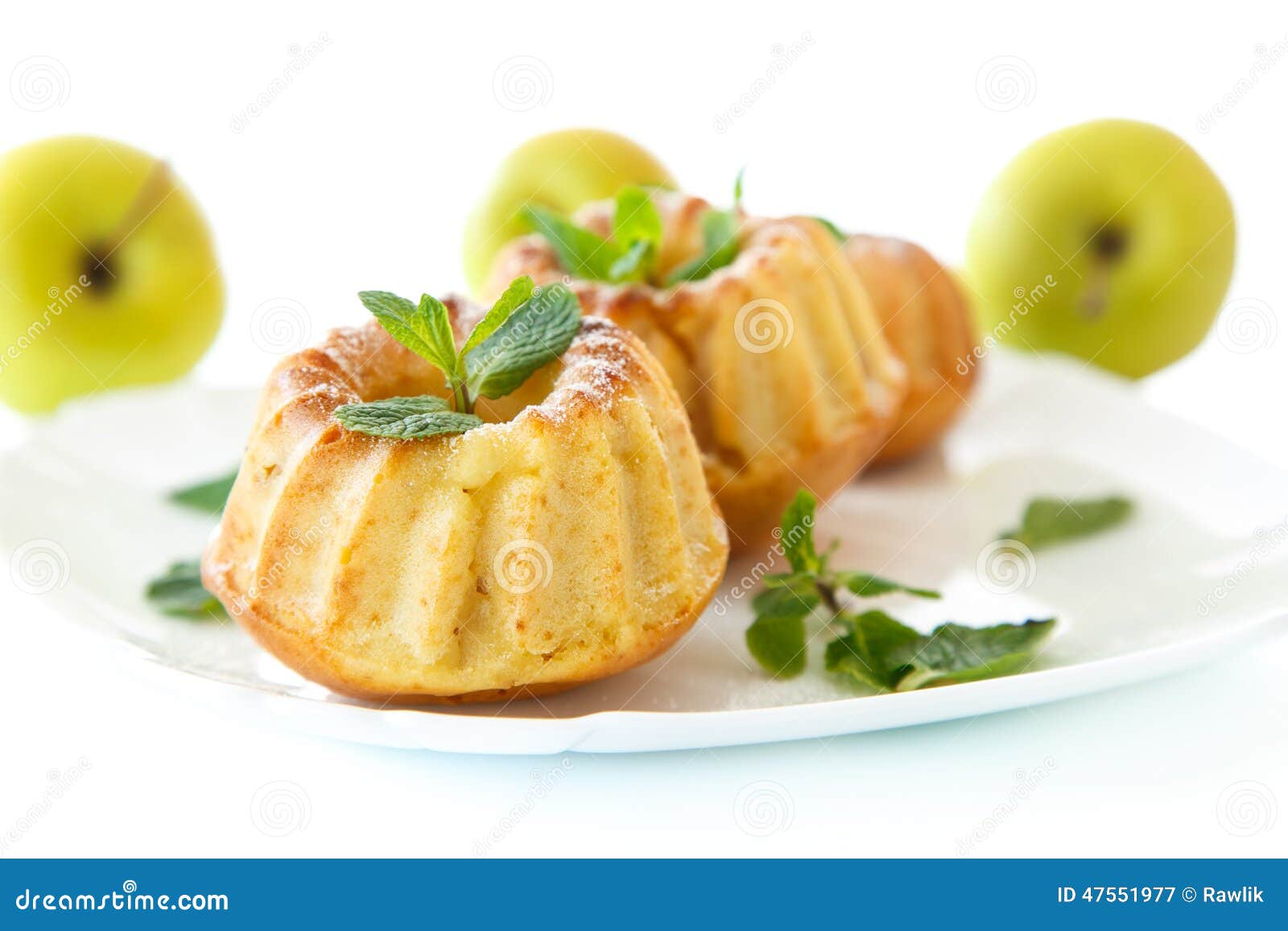 Sweet apple muffins with powdered sugar and mint on a white background