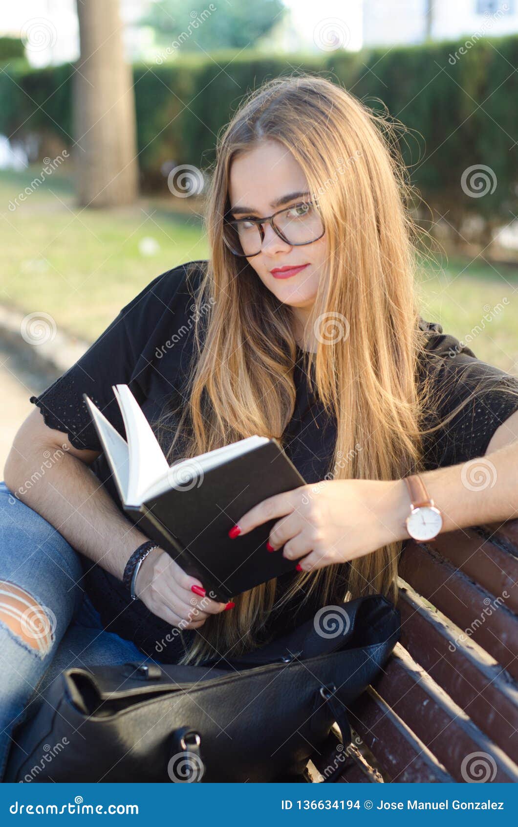Sweet Blonde Girl with Glasses Looking To You and Reading a Book in a ...