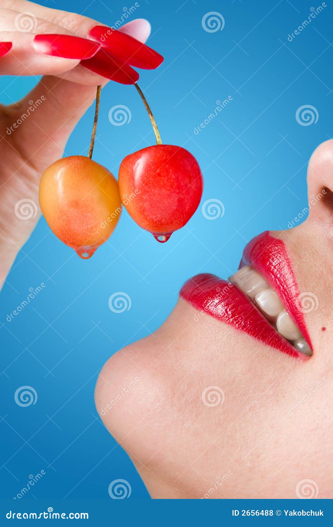 Close up of a sweet cherry and female lips