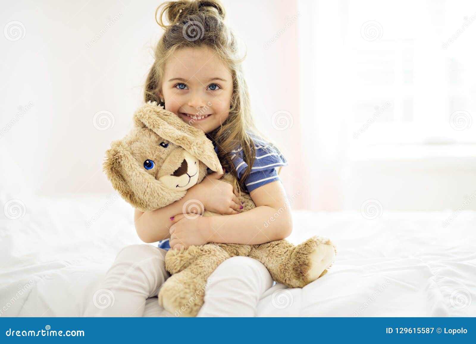 Sweet Little Girl is Hugging a Teddy Bear on Her Bed at Home Stock ...