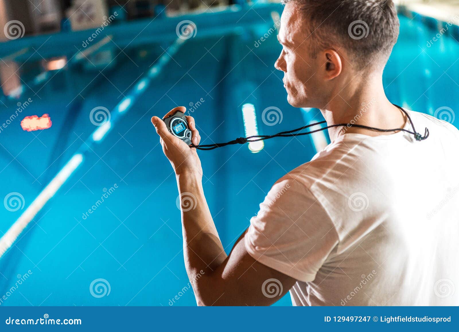 Handsome Swim Trainer with Stopwatch Standing at Competition Stock