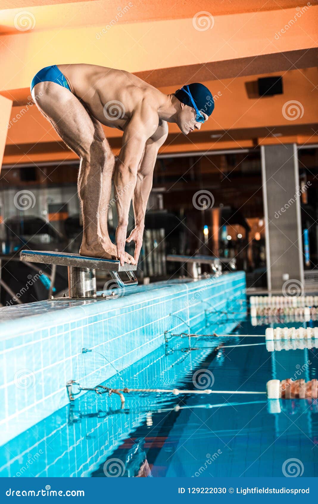 Swimmer Standing on Diving Board Ready To Jump into Competition