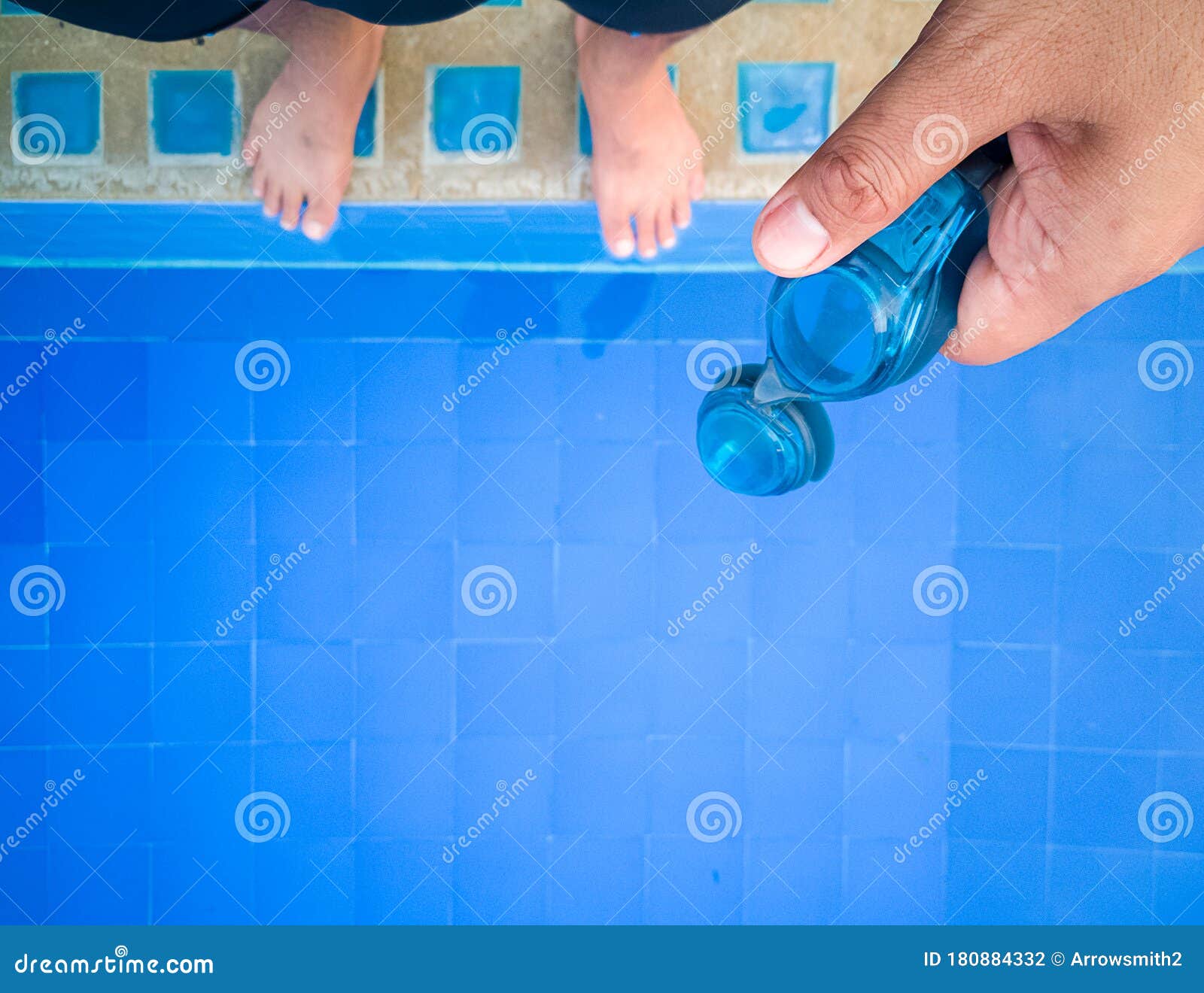 Swimmer `s Hand Holds the Swimming Goggles on the Pool Edge Stock Photo