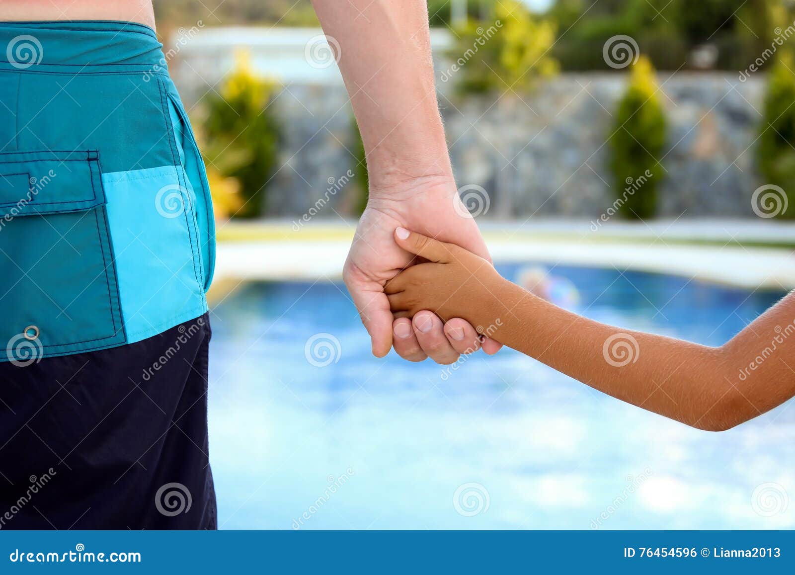 Swimming Pool. Father Holds the Hand of a Small Child on a Blue