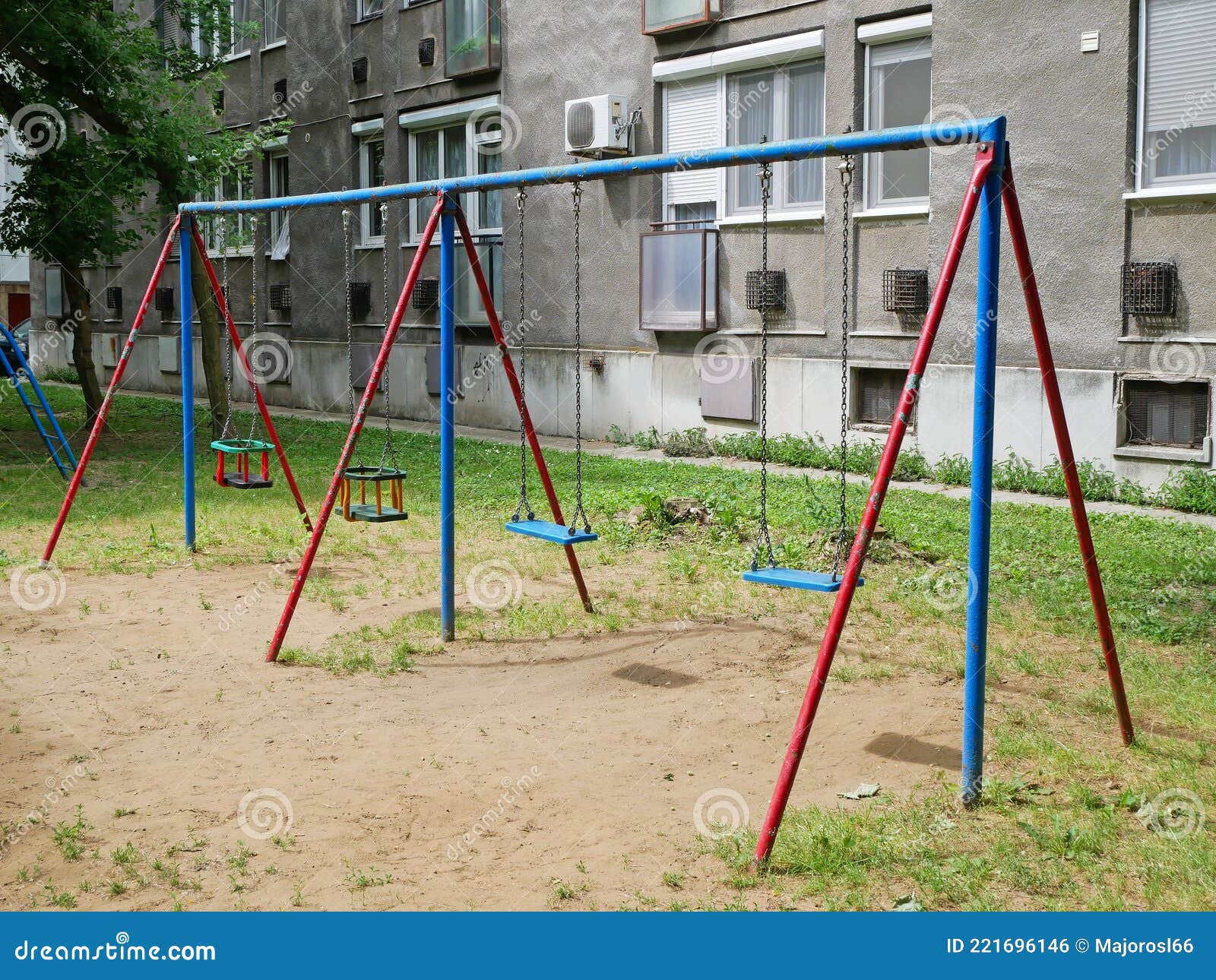 Swings at the Playground Next To an Apartment Building Stock Photo