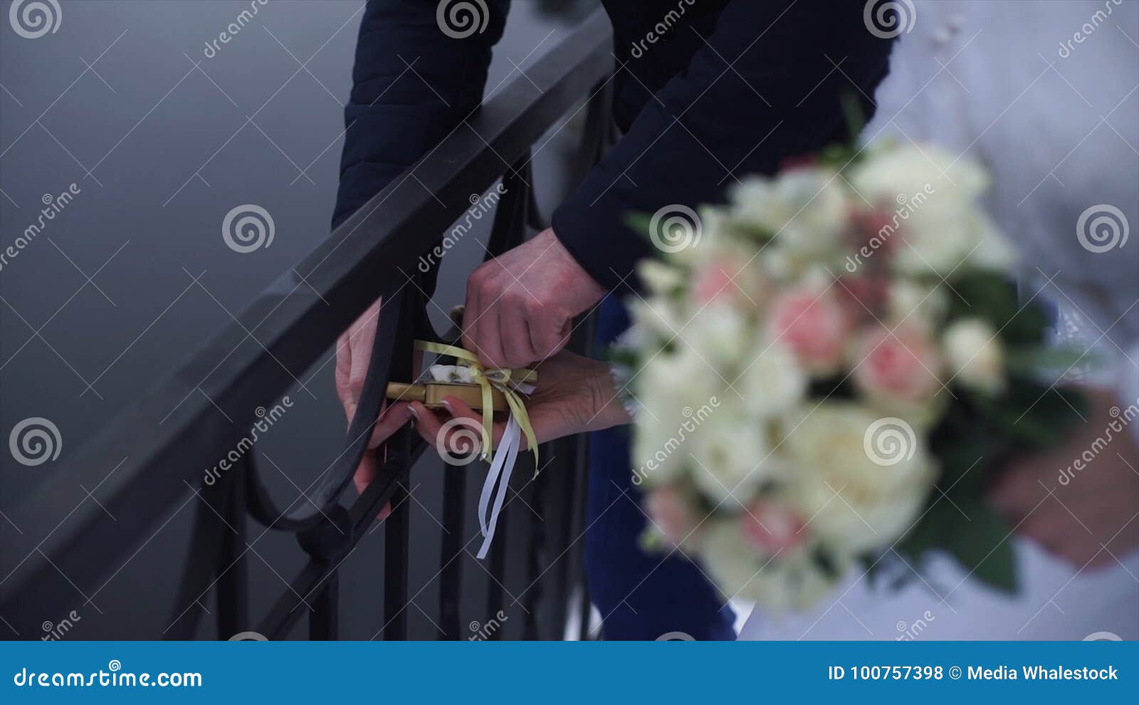 wedding , lock in hands of bride and groom. newlyweds fix the lock on the bridge as a  of love. padlock in