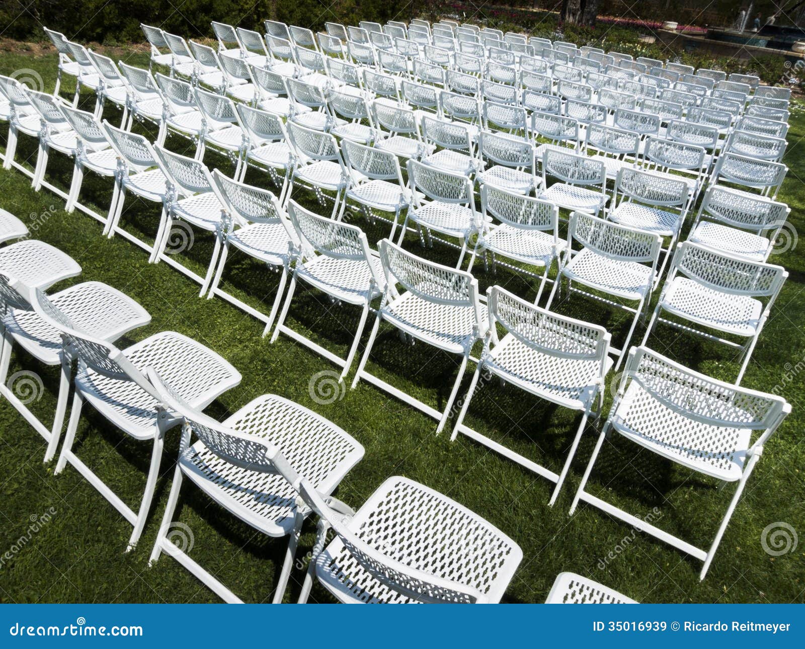 Symmetrical Pattern Of White Folding Chairs At Outdoor Garden