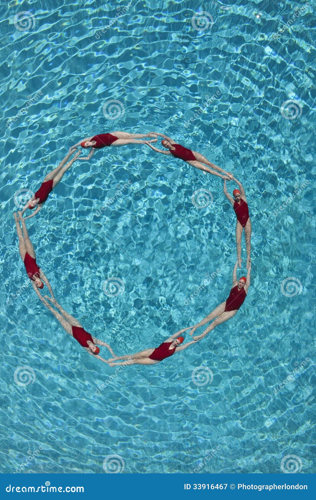 Group of synchronized swimmers forming a circle in pool