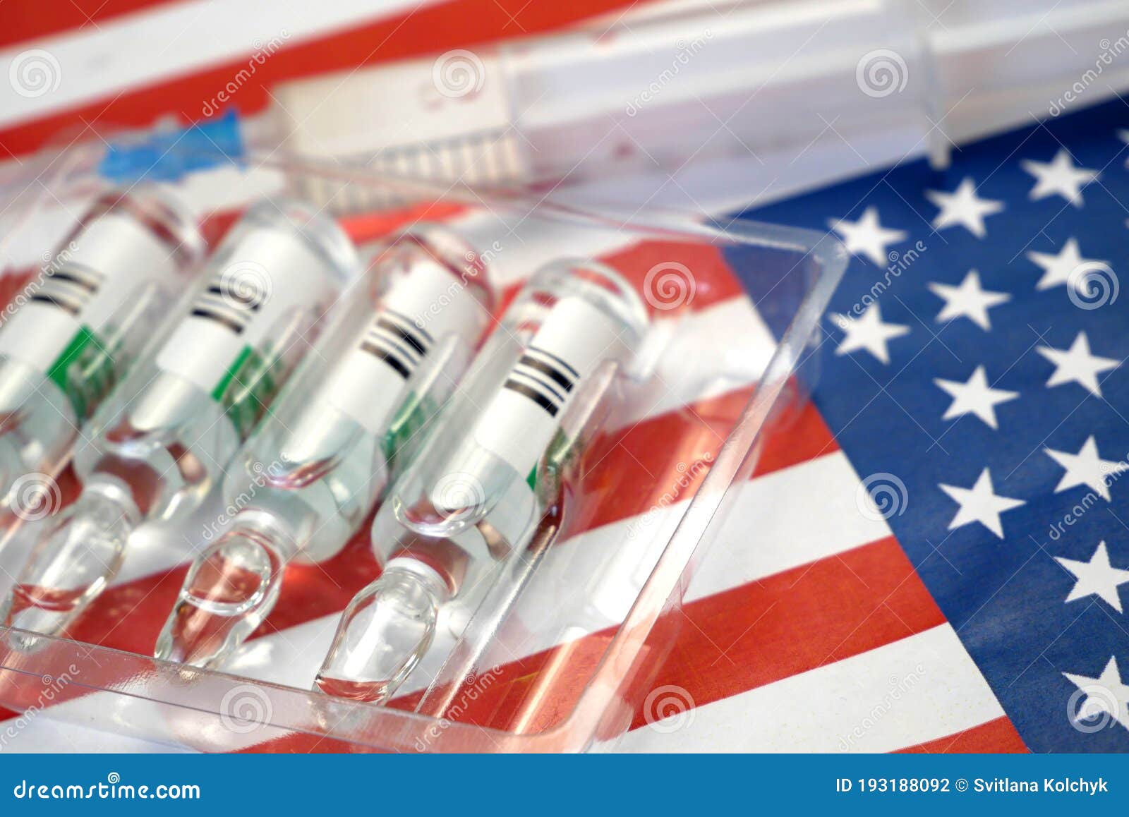 syringe with a vaccine is held by  hand in a glove on background of the usa flag, vaccine against coronavirus, operation warp