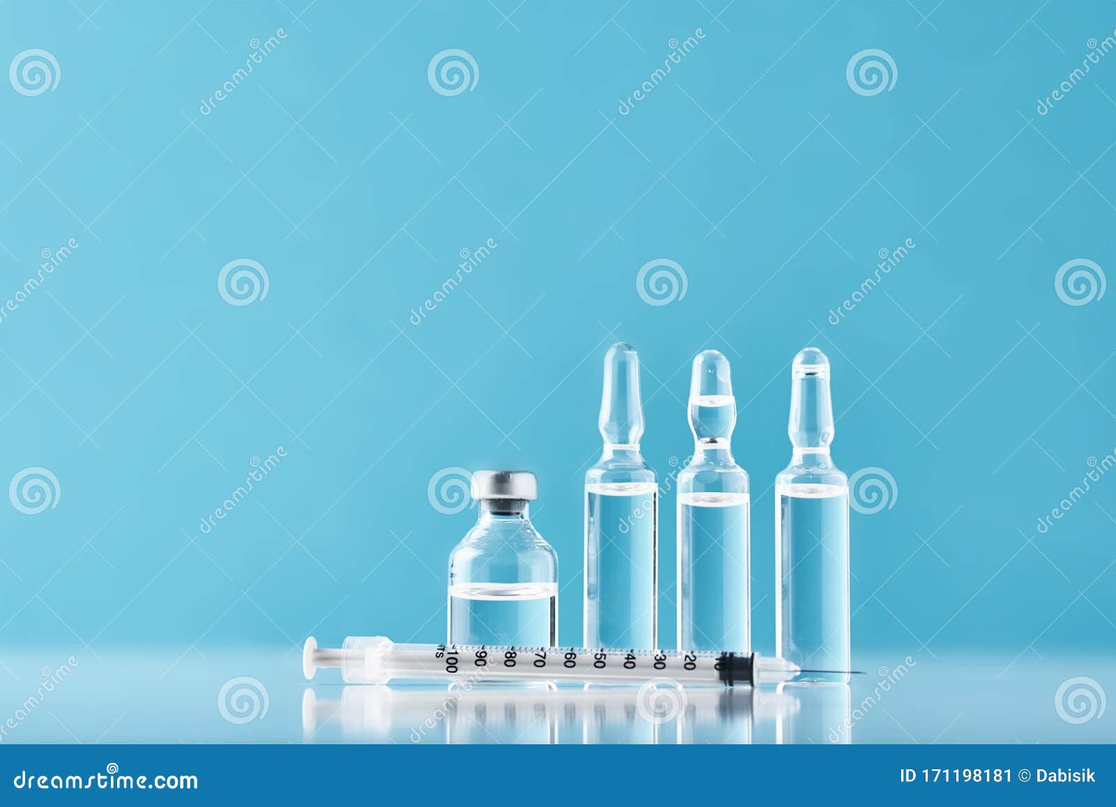 Syringes and Medicine Bottles with Medication on a Blue Background