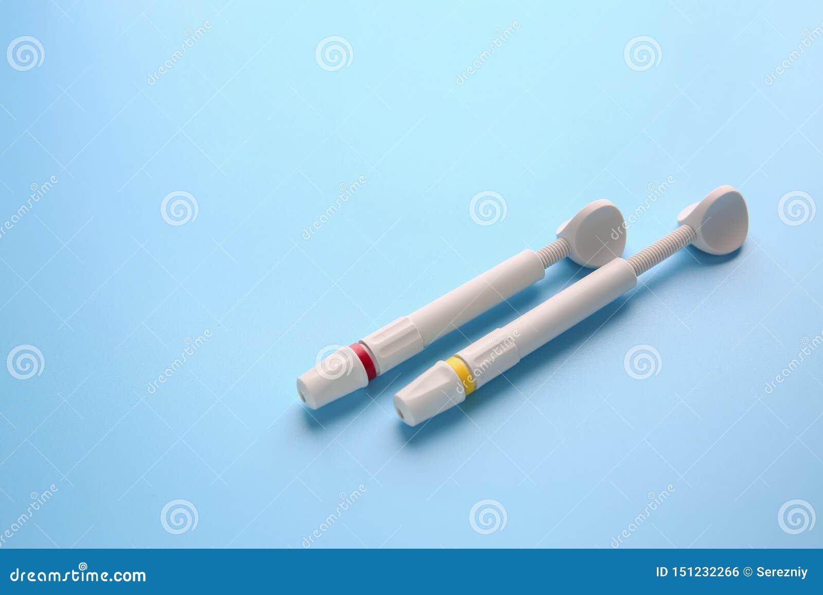 syringes of resin luting cement on color background