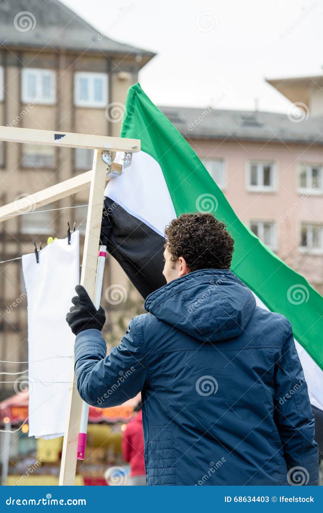 Syrische diaspora protesten tegen Syrische oorlog. STRAATSBURG, FRANKRIJK - BRENG 19, 2016 IN DE WAR: De mens die Syrische vlag houden als Syrische diaspora protesteert in centrum van Straatsburg aan het aan de kaak stellen van de Syrische aanvallen en toont solidariteit met de Syrische mensen