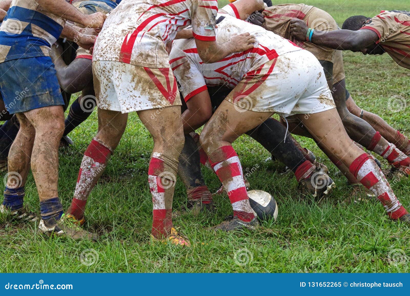 Szczegół rugby gracze ma zabawę w błotnistym polu. Szczegół rugby gracze ma ciężkie chwile w błotnistym polu