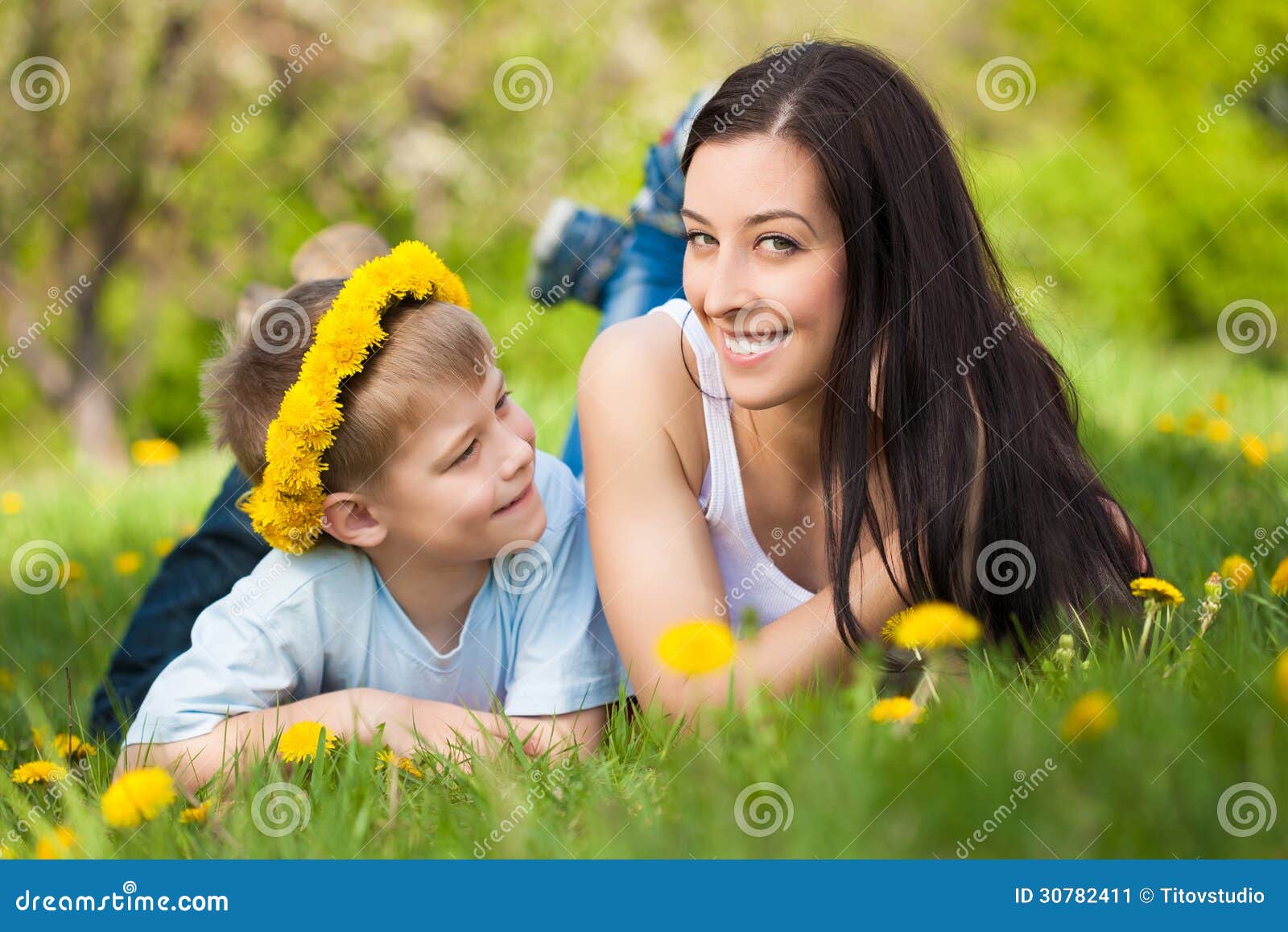 Szczęśliwa rodzina w zielonym parku. lato. Szczęśliwa rodzina z dandelions w zielenieje parka