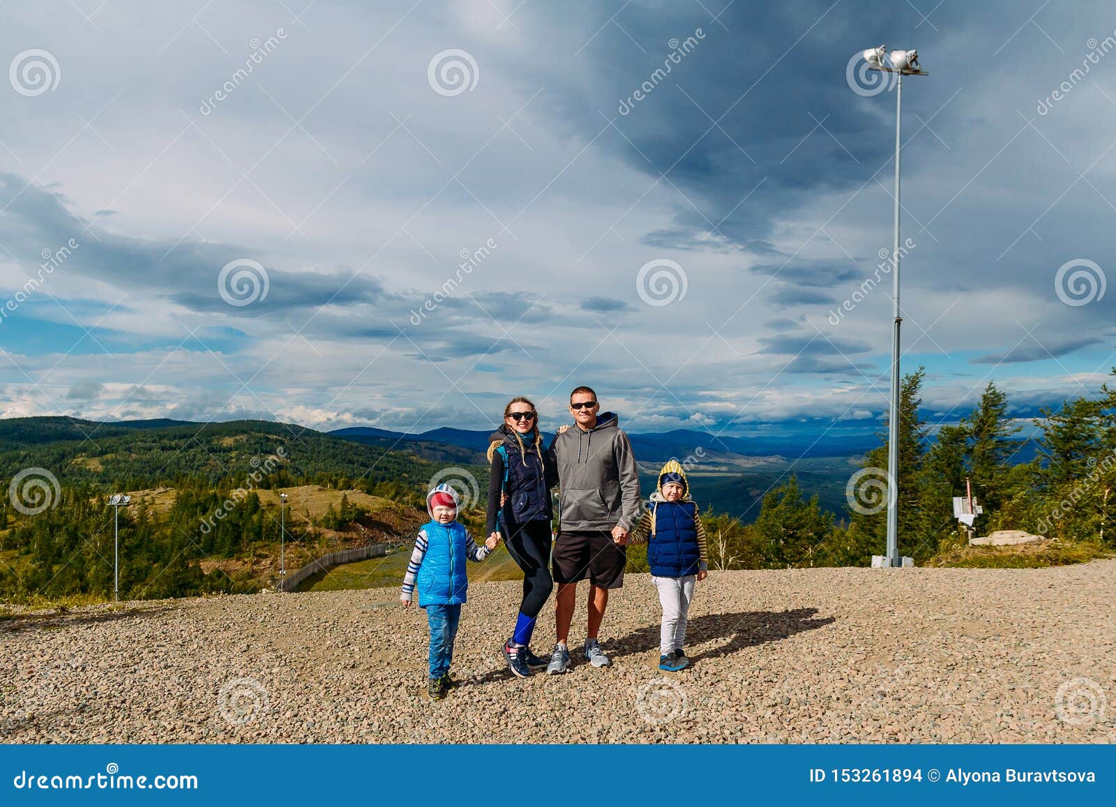 Szczęśliwy rodzinny spadek w górach mama, tata i dwa dzieciaka outdoors,