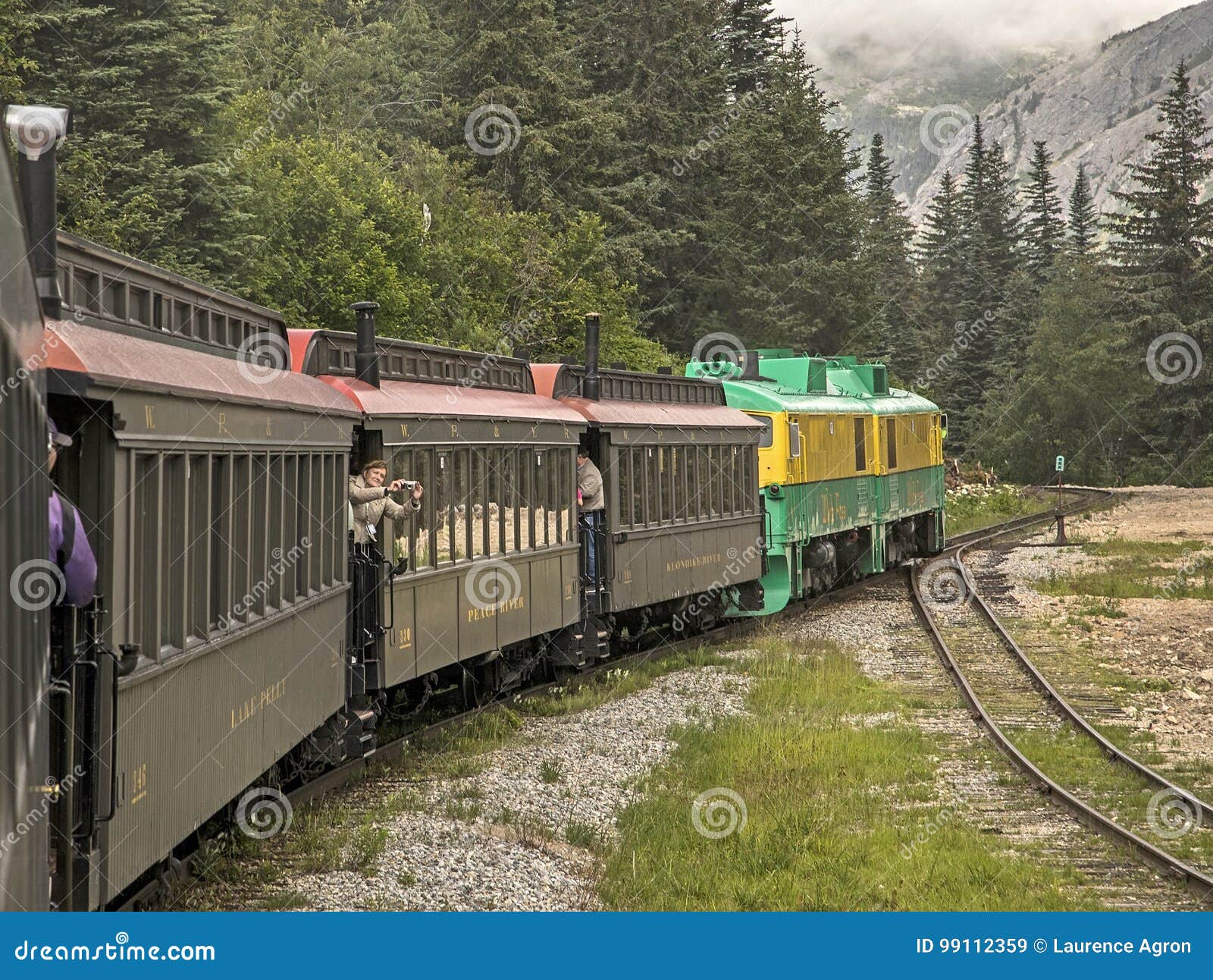 Szenischer weißer Durchlauf u. Yukon-Weg. Touristen, die ihre Zeit an Bord des weißen Durchlaufs u. der Yukon-Wegeisenbahn, die, genießen aufgebautes im Jahre 1898 Gleichlaufendes mit dem Klondike-Goldrausch im Yukon-Territorium war Es wurde im Jahre 1982 eingestellt, aber wieder belebt im Jahre 1988 als ausschließlich touristische Eisenbahn, die Schaulustige durch ausgezeichnete Landschaft in einer Stunde und eine Viertelfahrt vom weißen Durchlauf, Yukon hin- und herfährt, das einen Aufzug von 2.864 Fuß unten zu Skagway, Alaska am Meeresspiegel hat Dieses Foto wurde am 27. Juli 2017 gemacht