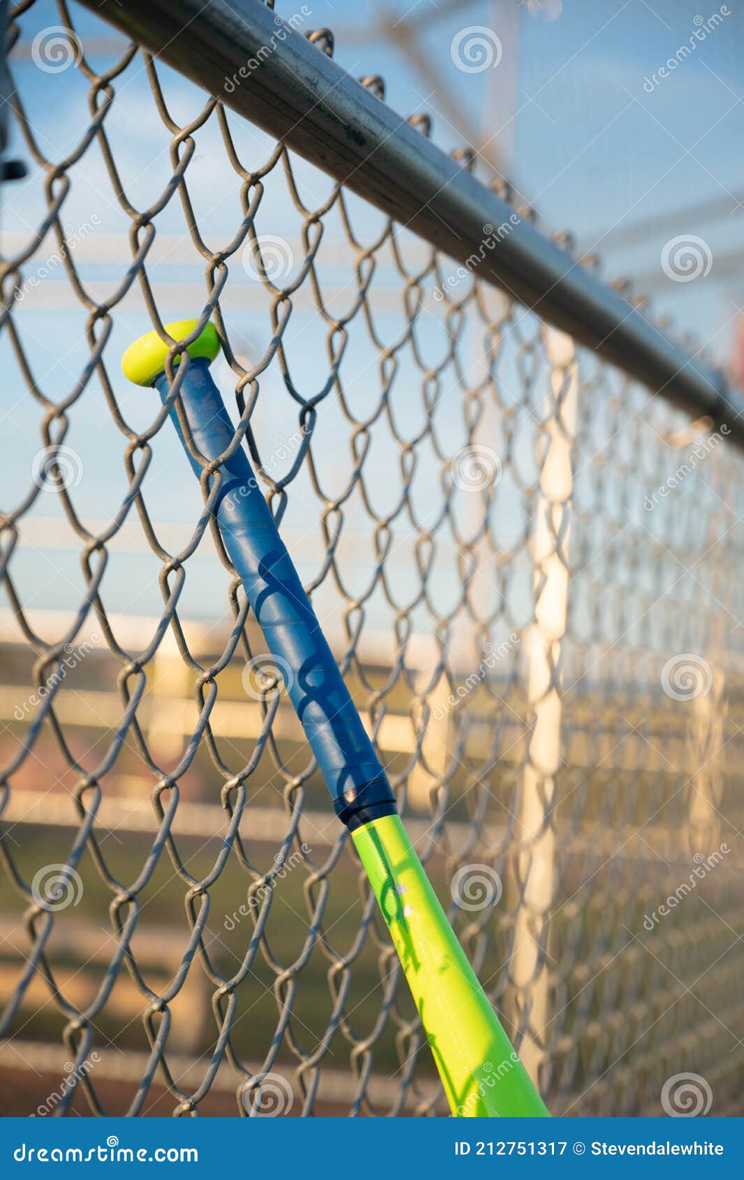 t-ball baseball bat hanging on dugout fence