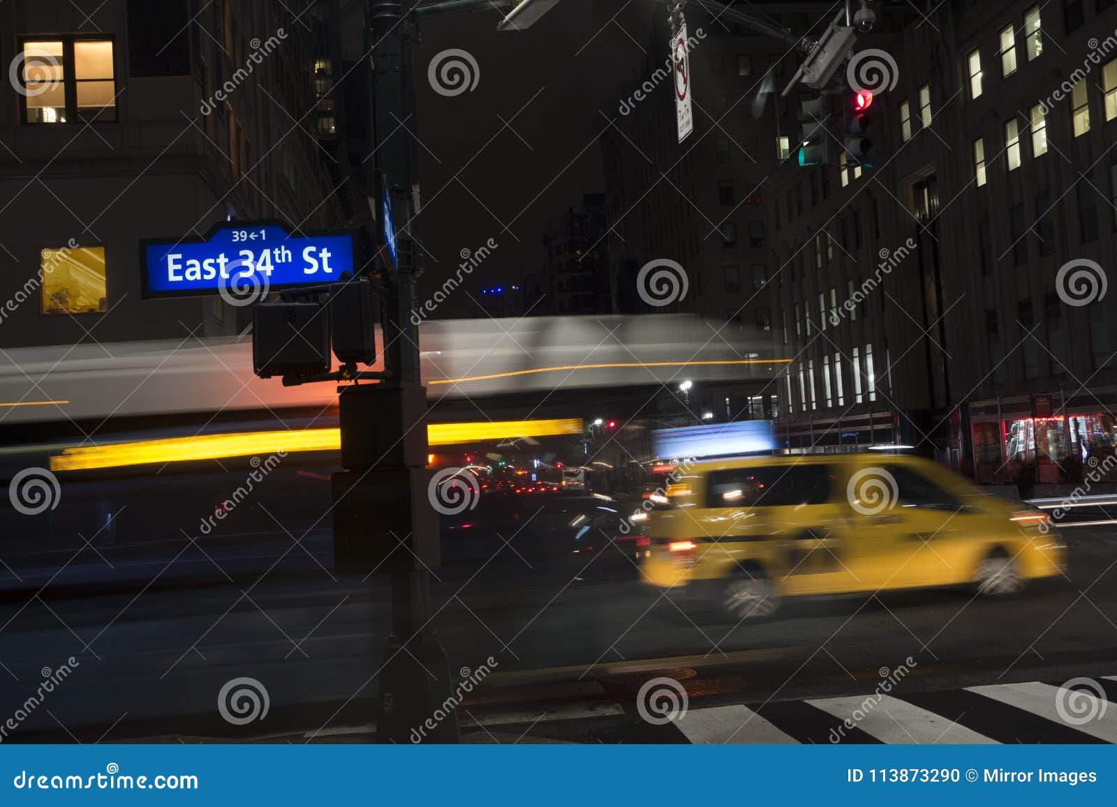 34ta calle Nueva York del autobús del taxi móvil del nyc en la noche. La falta de definición de movimiento New York City en edificio de la calle del taxi de la noche el 34to se enciende