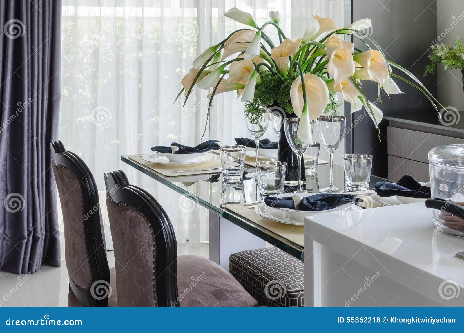 Table Set on Glass Dinning Table with Vase of Flower Stock Photo