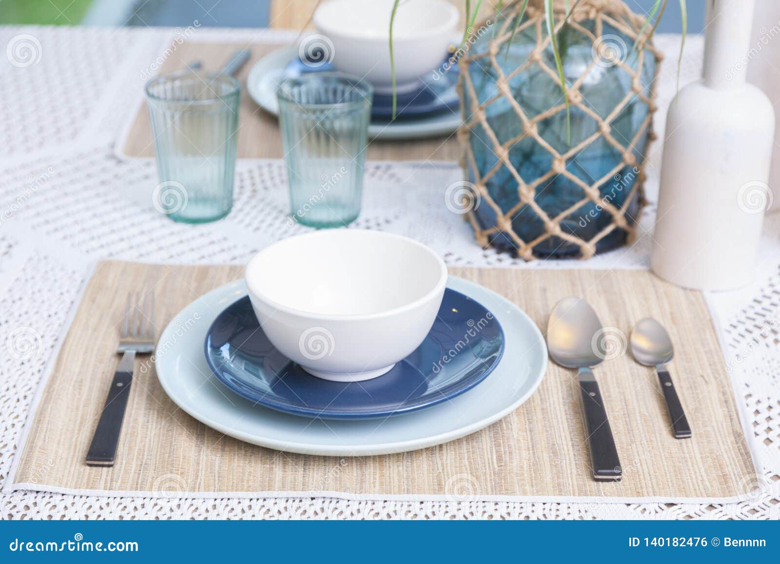 Table Setting with Blue Plate, Cutlery and Glass Vase in Dinning Room ...