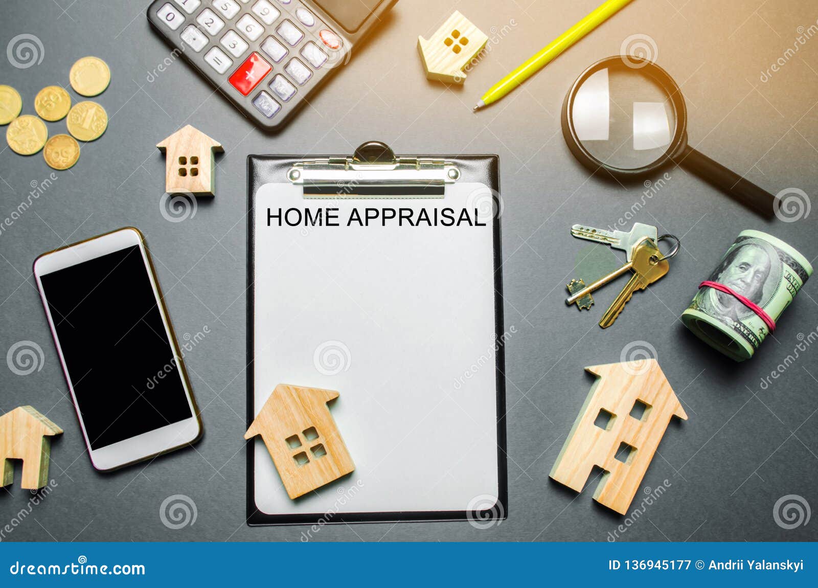 table with wooden houses, calculator, coins, magnifying glass with the word home appraisal. the contract for real estate appraisal