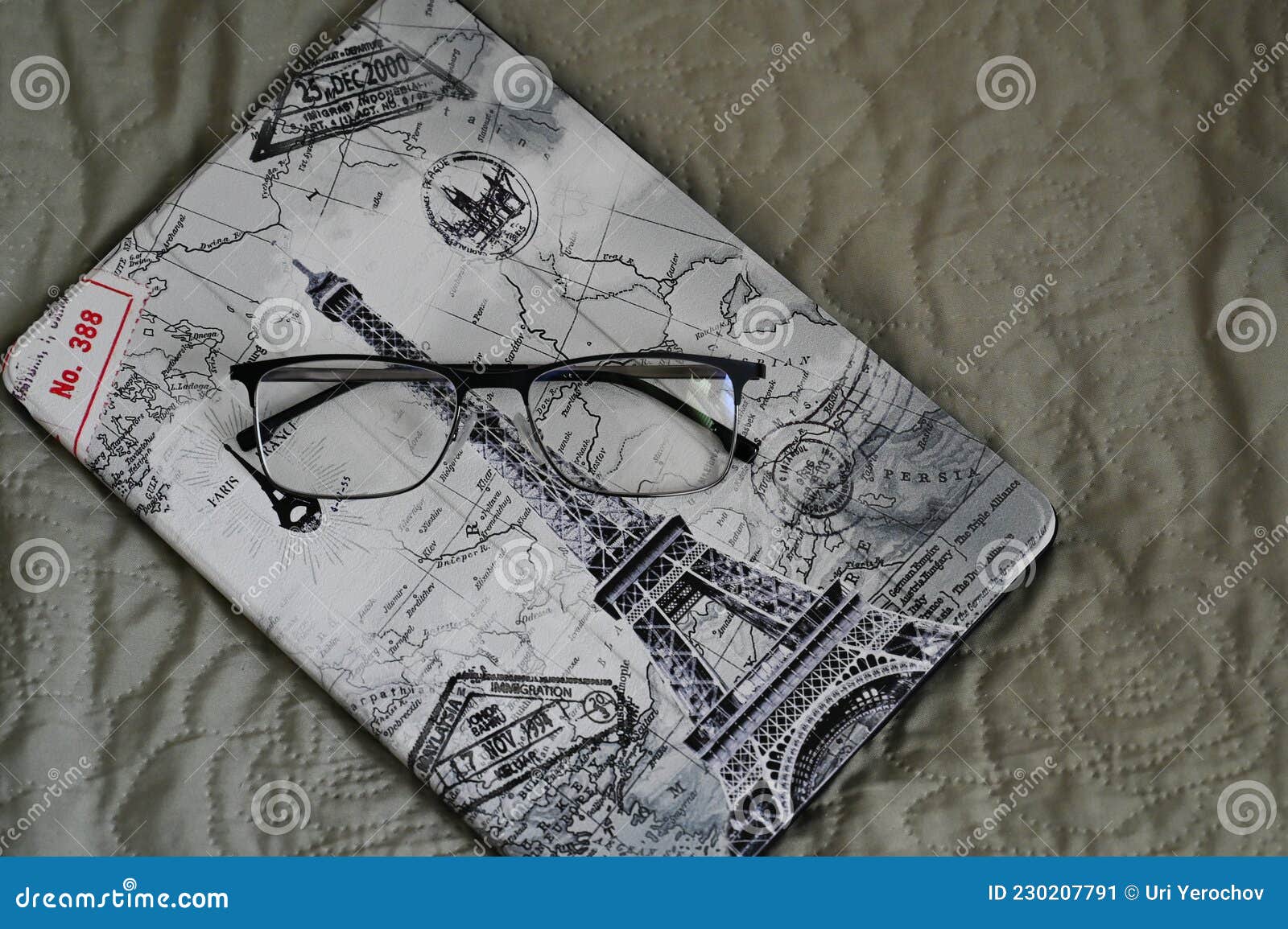 The Tablet in the Case is Lying on the Bed with Glasses on it Stock