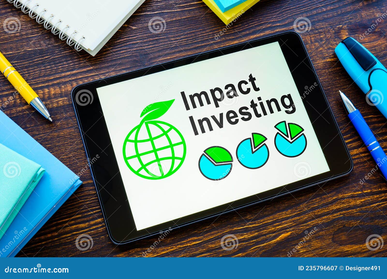 tablet with impact investing info and notebooks.