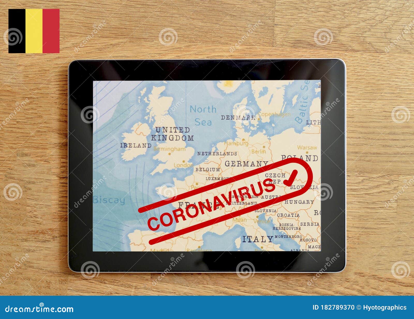 a tablet pc which is displayed with map of belgium and coronavirus text on the wooden table stock photo image of contagion phrase 182789370