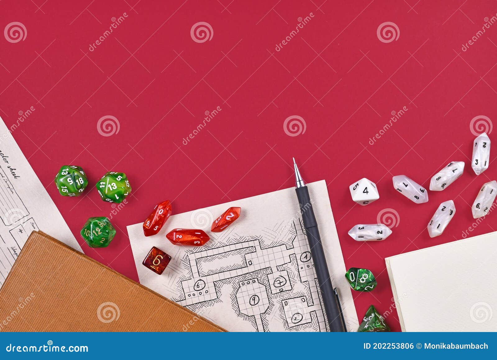 tabletop role playing flat lay with rpg game dices, hand drawn dungeon map, rule books and pen at bottom of red background