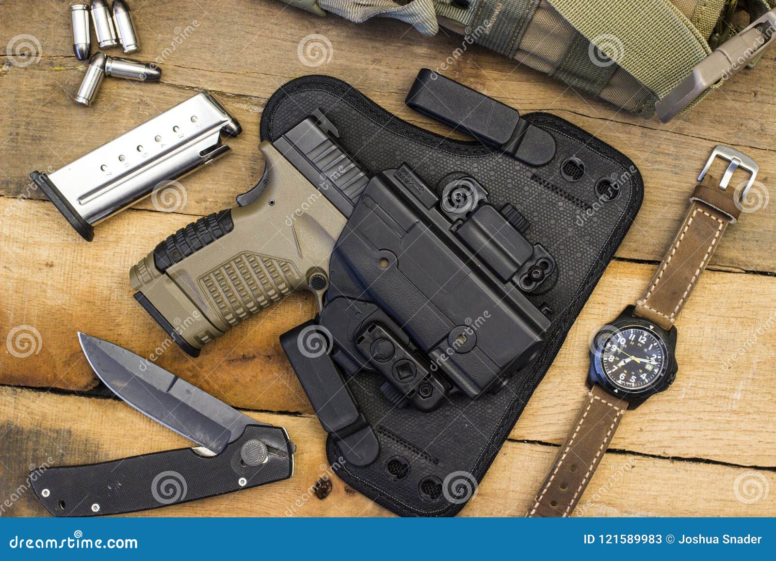 tactical handgun and gear including watch, bullets, knife, holster, bag