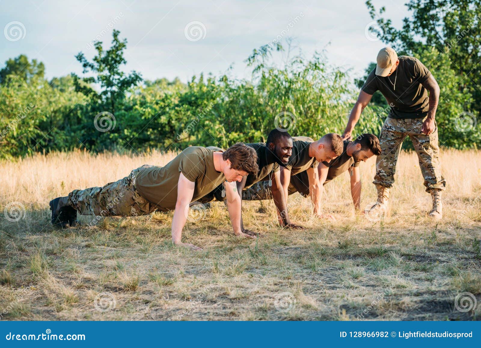 Tactical Instructor Examining Multicultural Soldiers in Military Uniform Doing Push Ups Stock