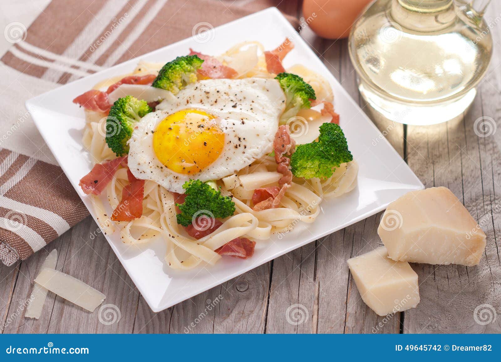 Tagliatelle Pasta with Broccoli, Prosciutto and Fried Egg. Stock Photo