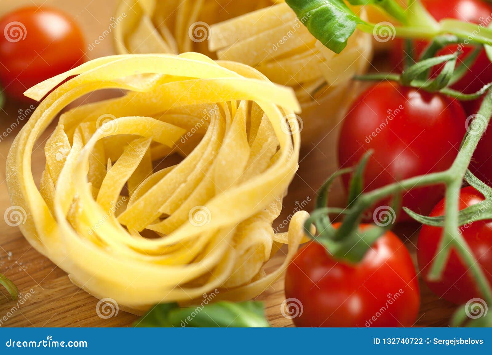 Tagliatelle Pasta with Fresh Basil and Tomatoes on Rustic Table. Stock