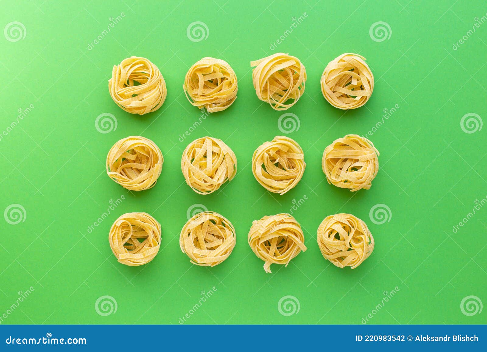 Tagliatelle Raw Pasta Nests on Green Background, Top View Stock Photo