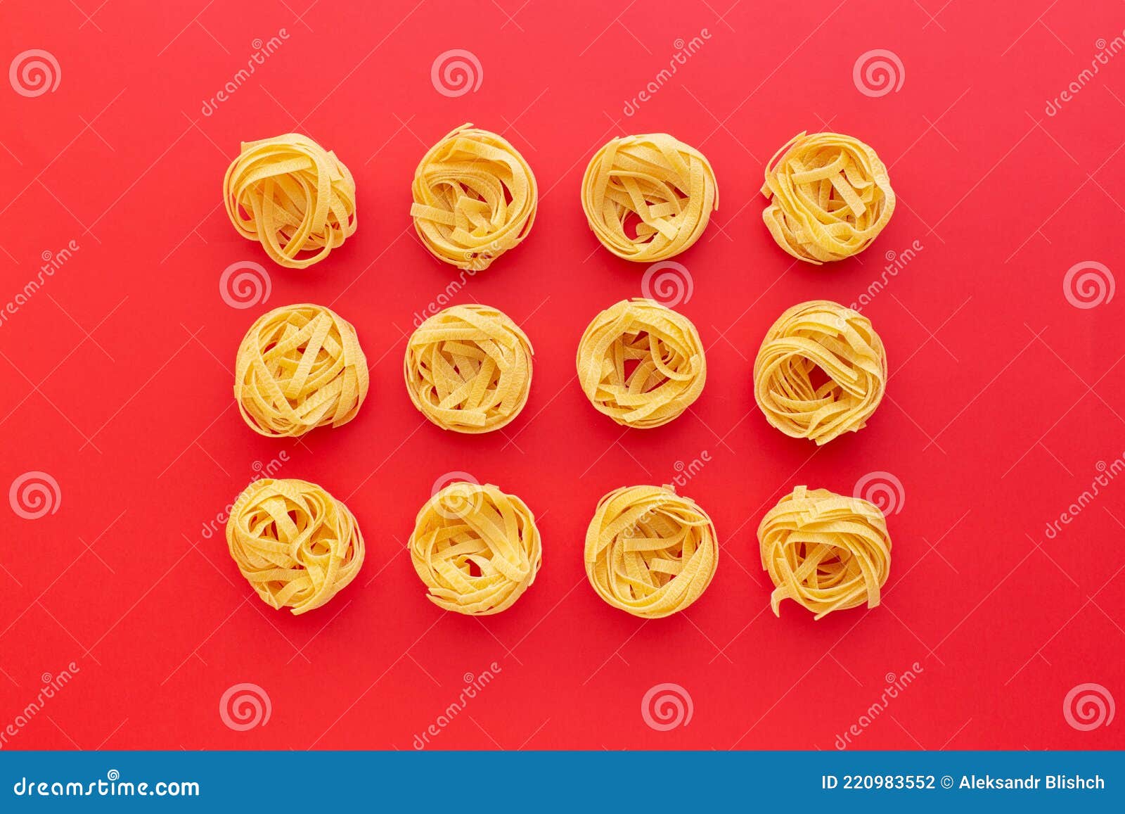 Tagliatelle Raw Pasta Nests on Red Background, Top View Stock Photo