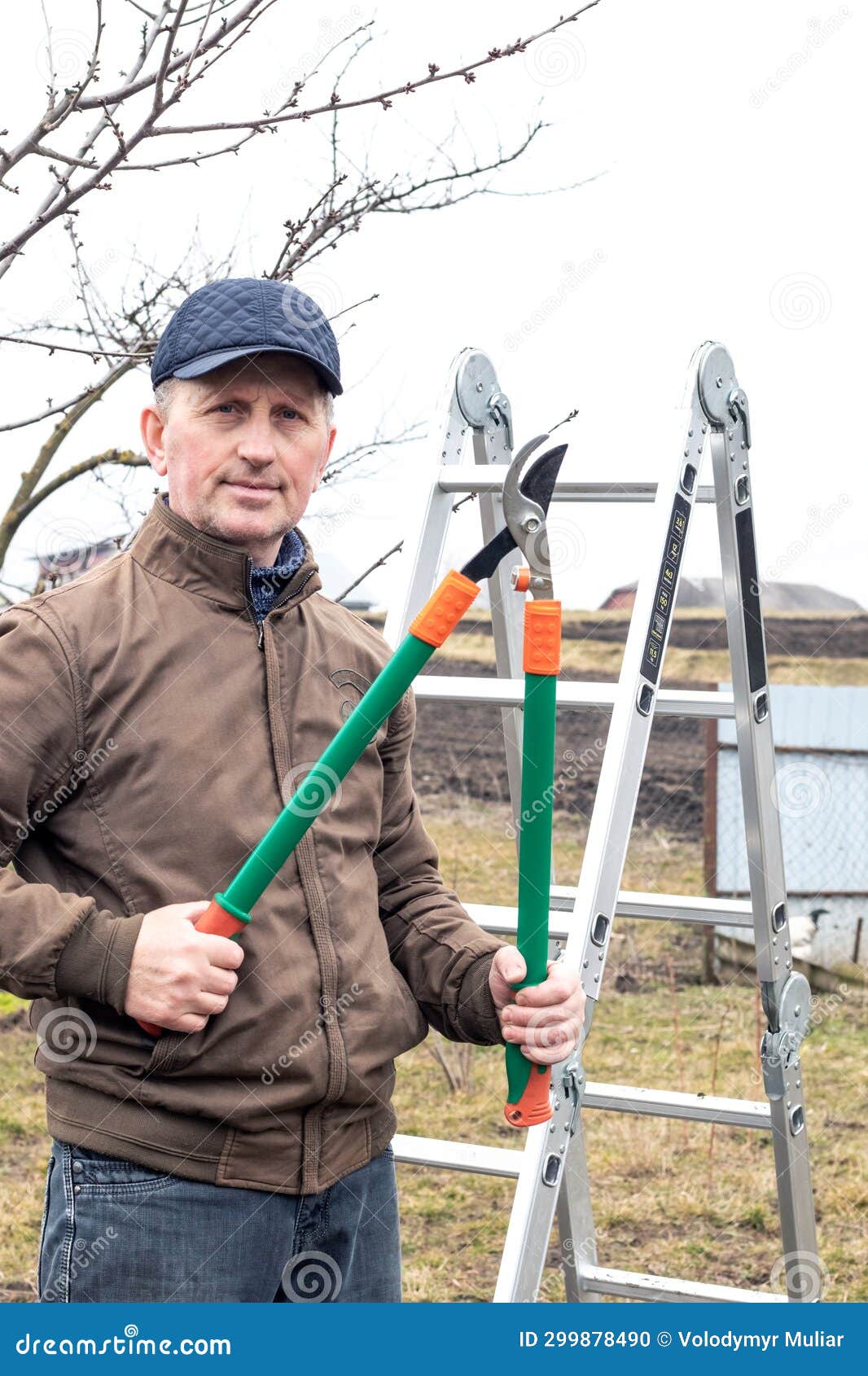 Le Jardinier Tient Dans Ses Mains De Grands Ciseaux Pour Couper Des Branches  D'arbres Un Homme Dans Le Jardin Avec Des Sécateurs