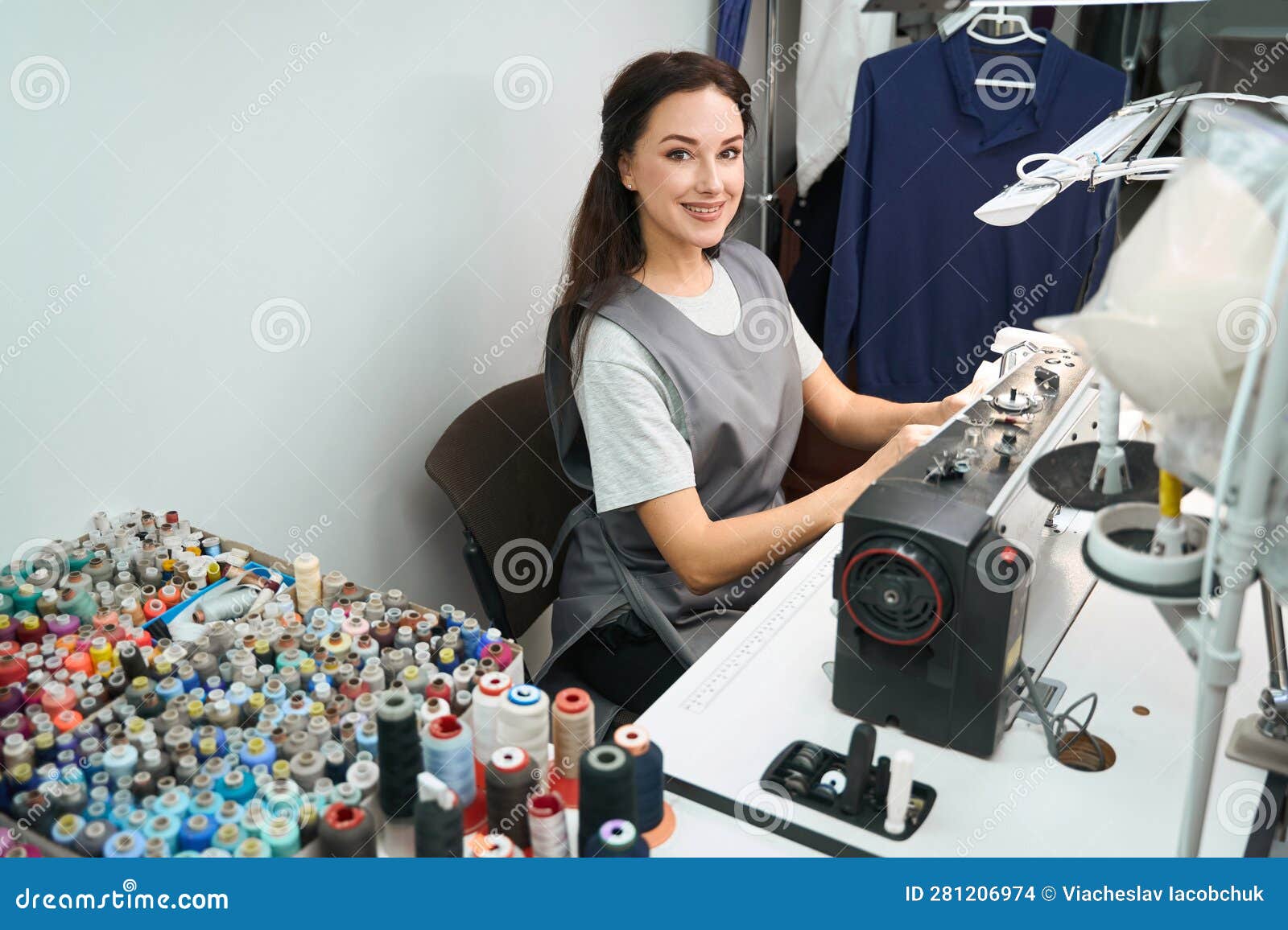 Tailor Sitting at Sewing Machine, Processing Clothes after Dry Cleaning