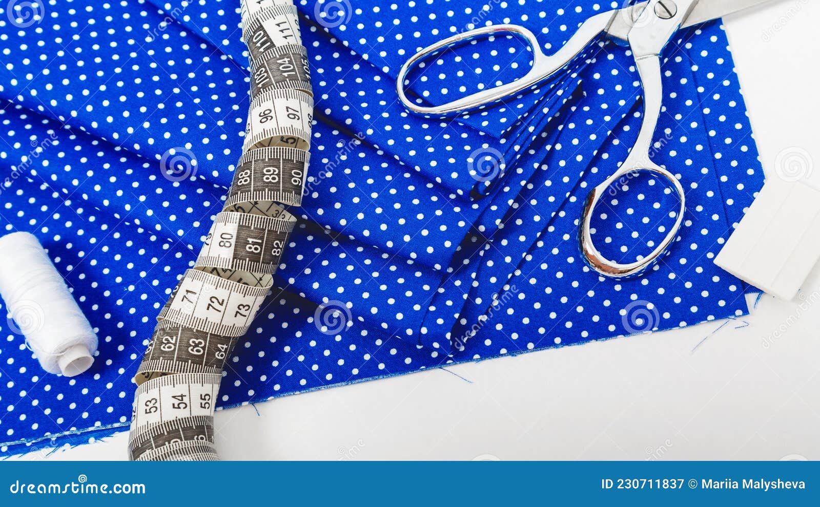 Tailor Work Place with Thread, Scissors, Blue Fabric, Pattern, Tools