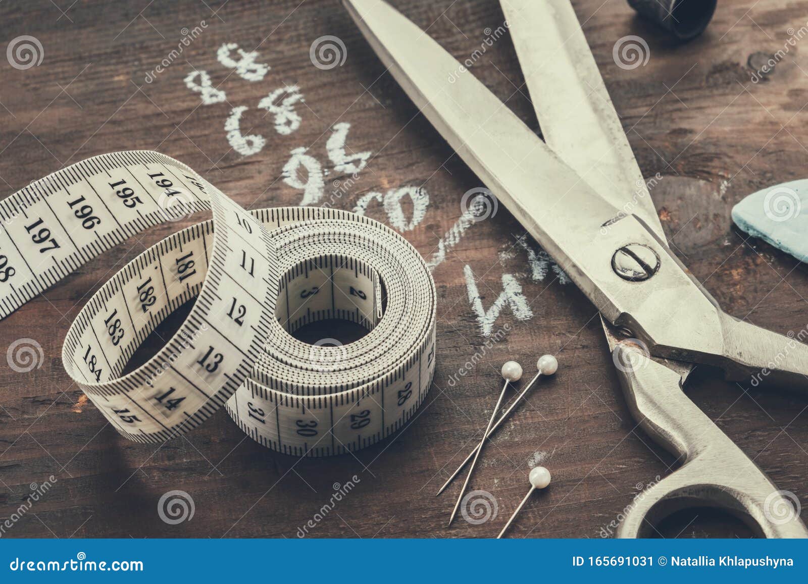 Sewing items: tailoring scissors, measuring tape, thimble, spools
