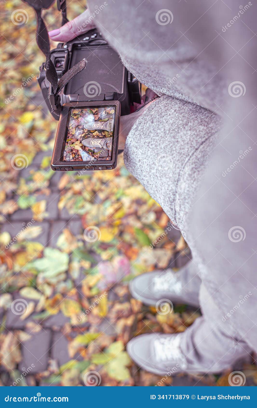 take photos on the camera of legs against the background of autumn leaves