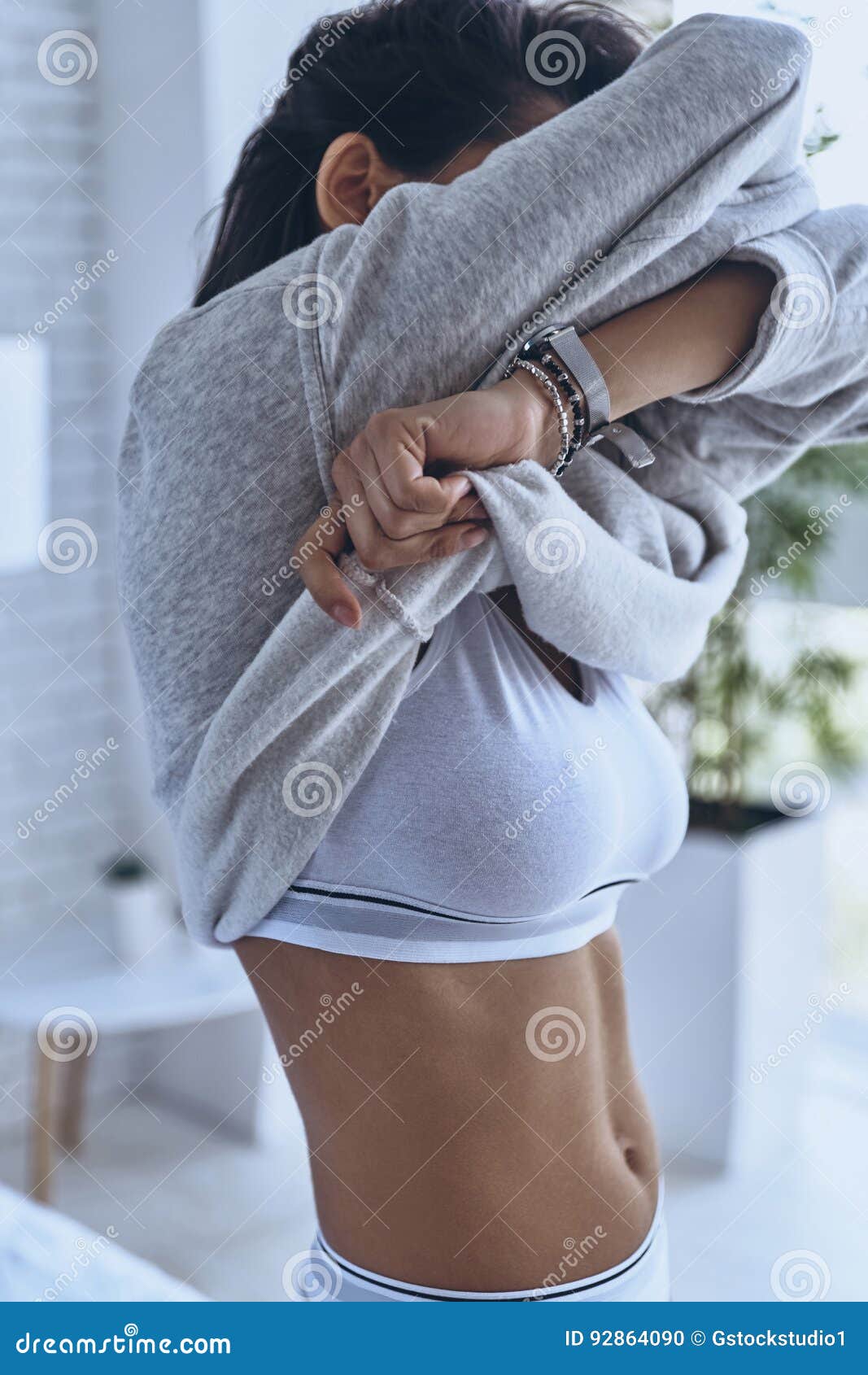 Photo about Close-up of young woman in underwear taking off her