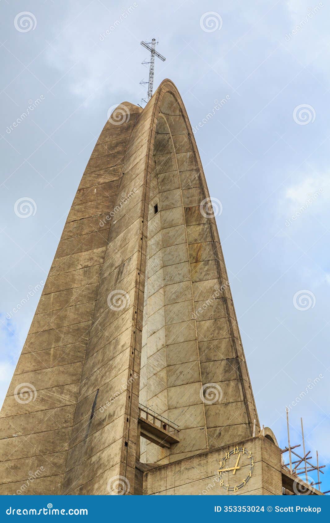 a tall building with a cross on top and a clock on the side