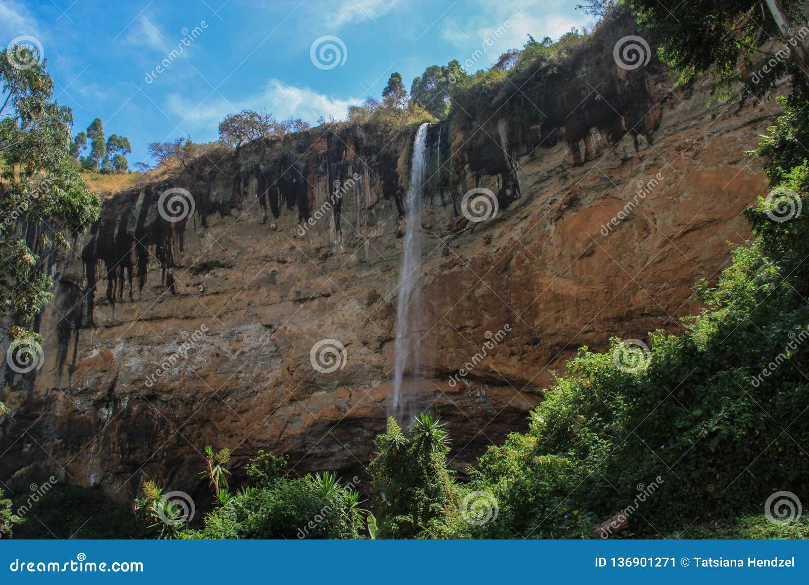 tall and thin sipi falls flowing among rocks