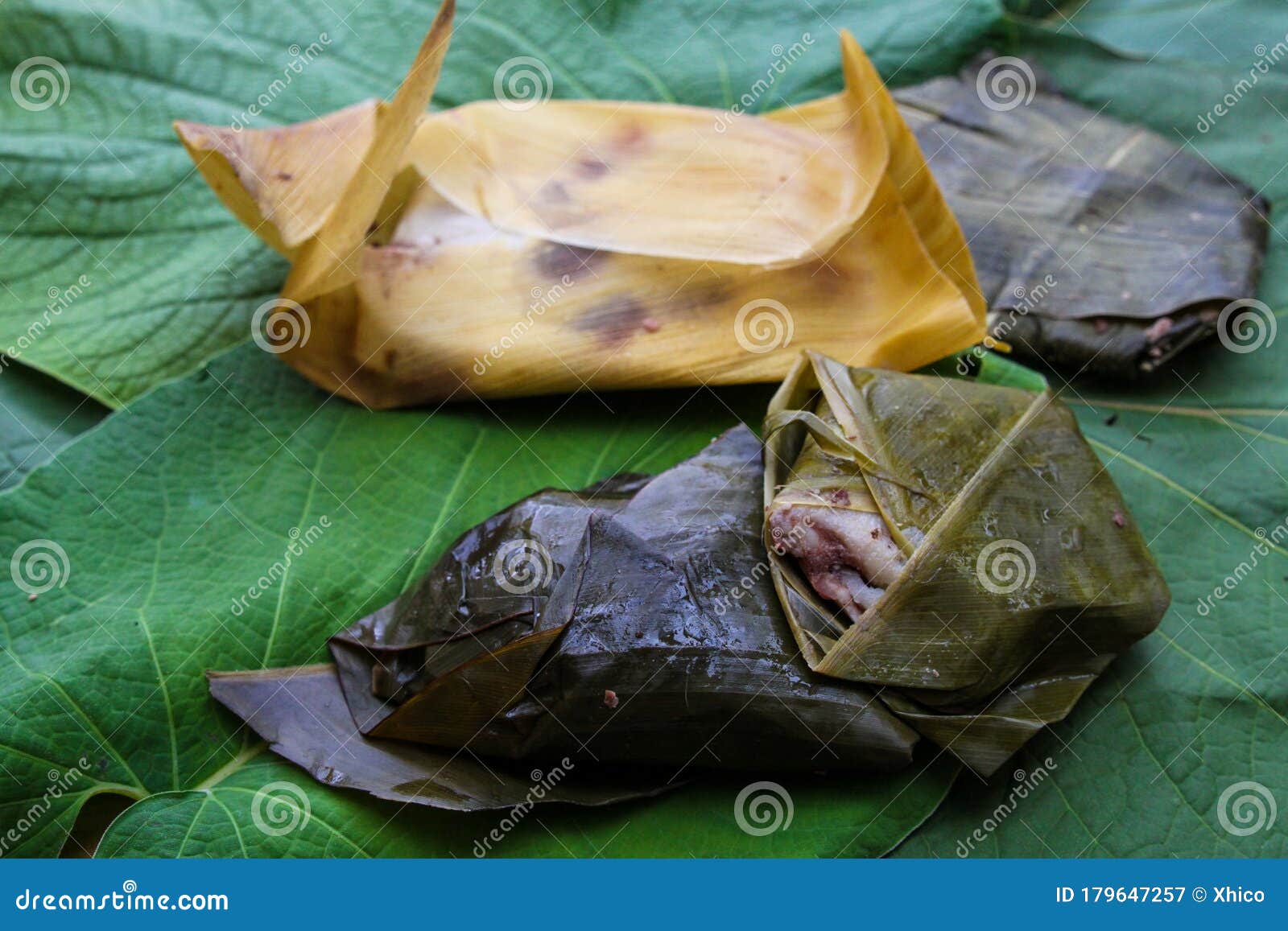 tamales made with beans wrapped in corn husks and hoja santa leaves