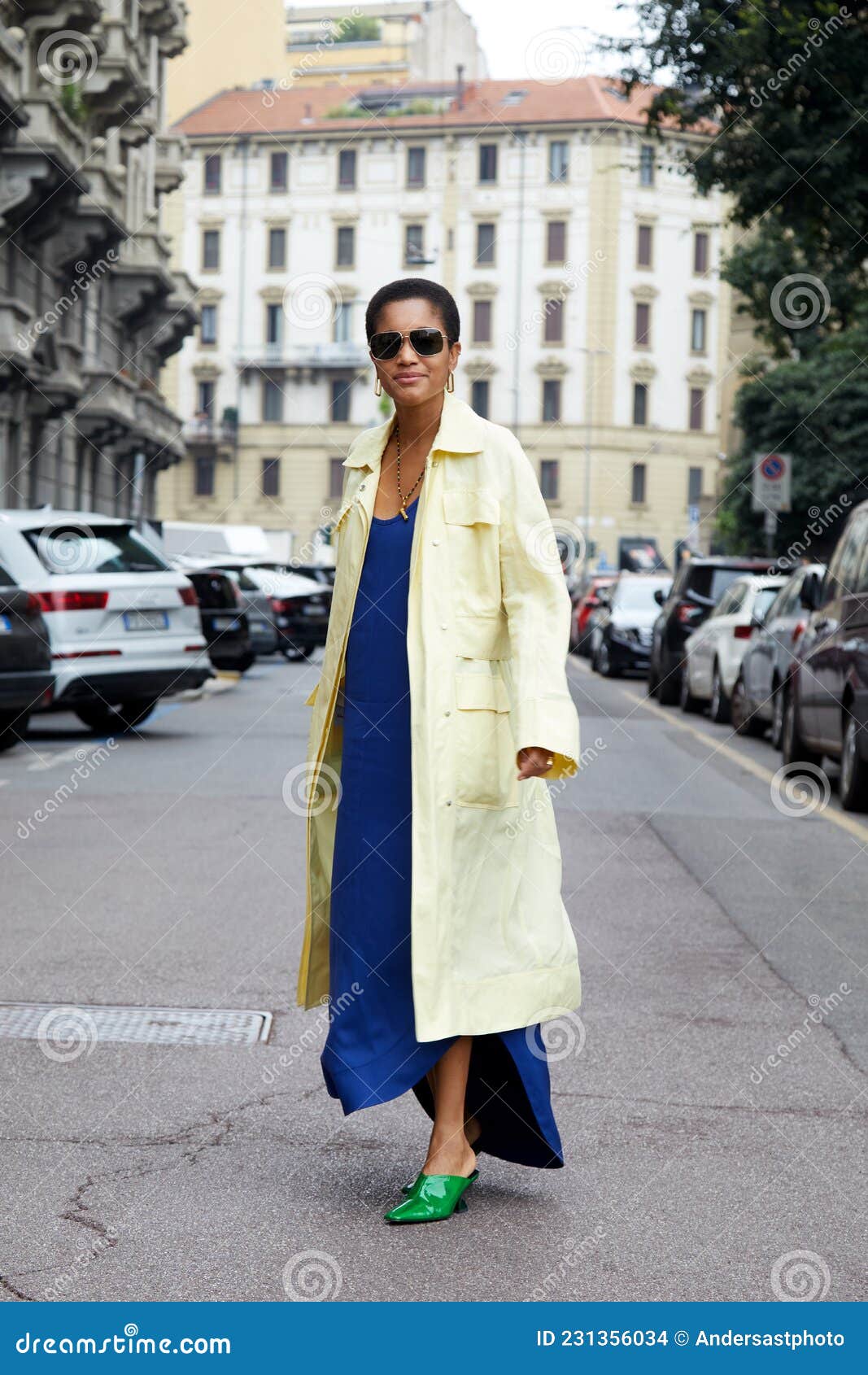 Tamu Mcpherson Con Abrigo Largo Amarillo Pálido Vestido Azul Eléctrico Y Zapatos Puntiagudos Verdes Antes editorial - Imagen de milano, 231356034