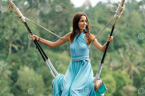 Tanned Beautiful Woman In A Long Turquoise Dress With A Train Riding
