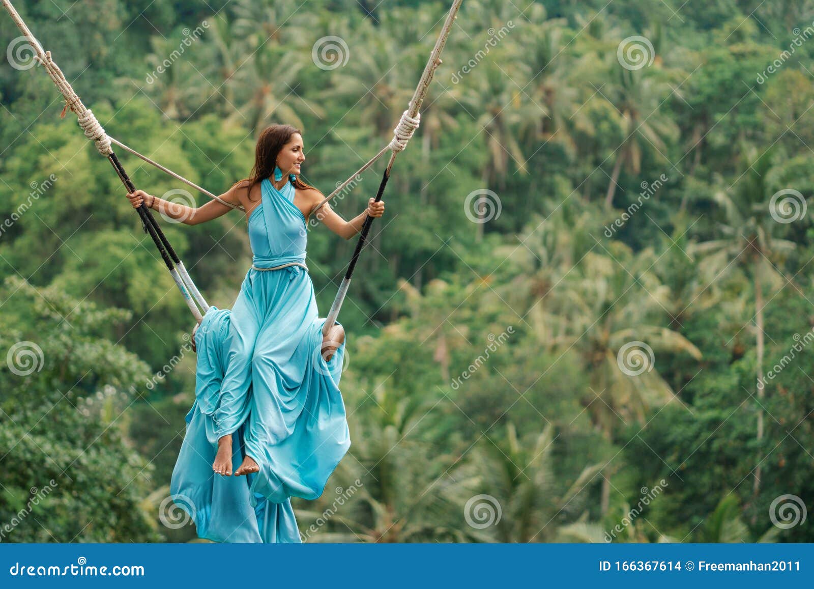 Tanned Beautiful Woman In A Long Turquoise Dress With A Train Riding