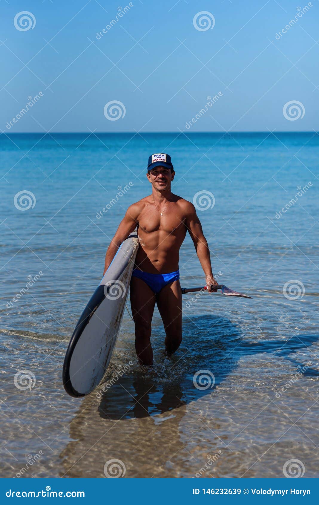 Tanned Man on the Beach of the Sea with a Surfboard and Oar in His ...