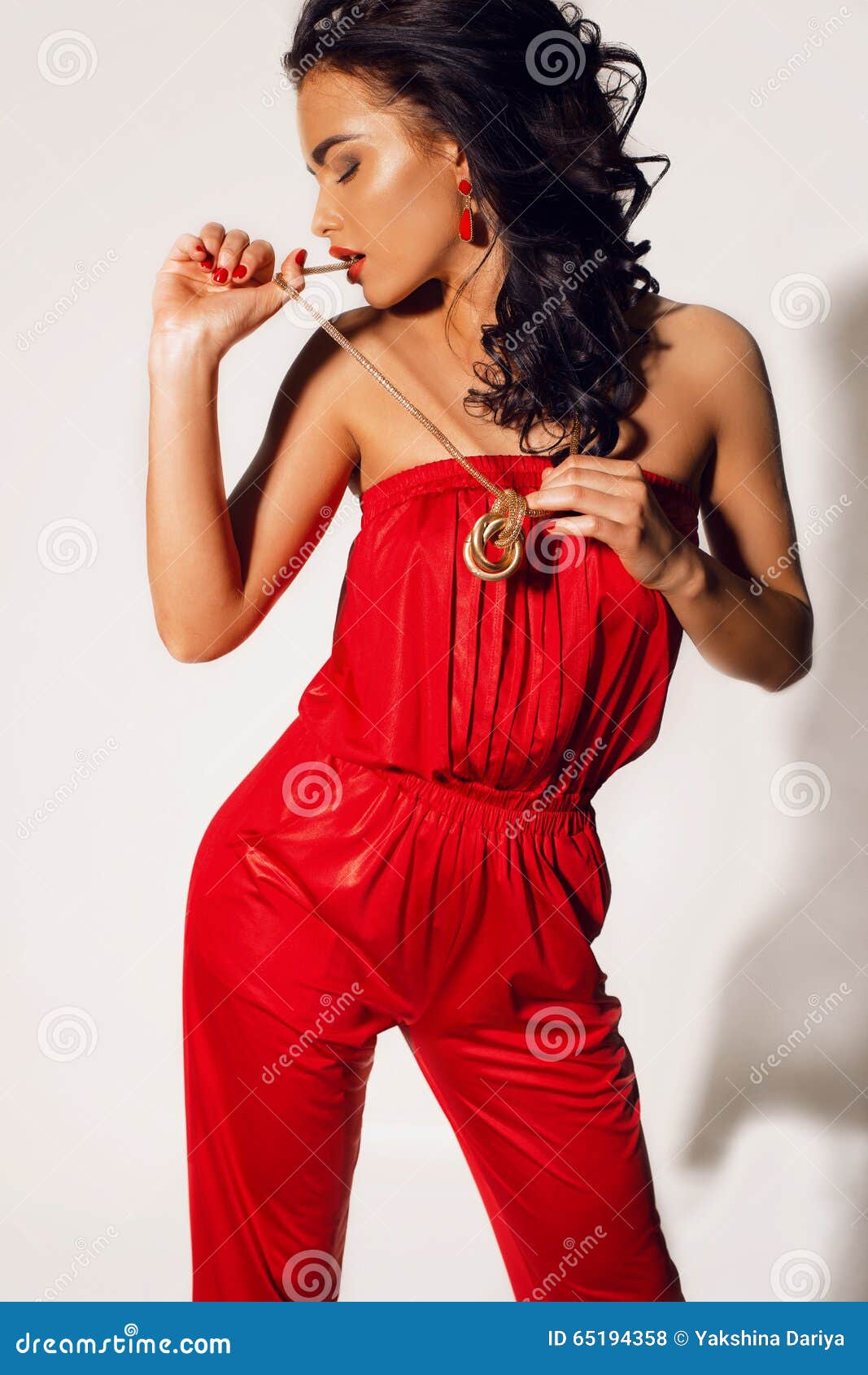 Tanned Woman With Long Dark Curly Hair Wears Elegant Red Suit With